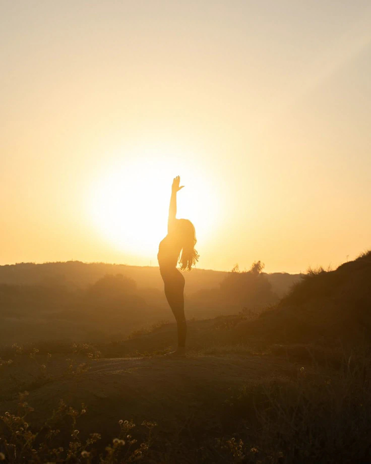 Mulher caminhando em um campo ao amanhecer, vestindo peças de algodão natural